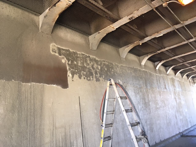 This image shows one of the underpass walls undergoing the sandblasting process in order to prepare the wall for the new mural.